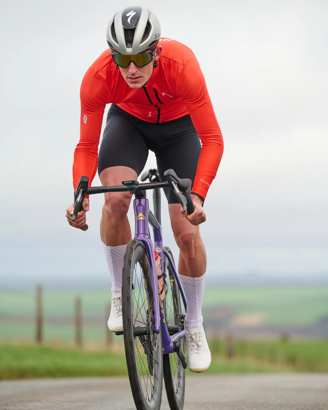 Ben Millar riding out of the saddle on a climb in race kit