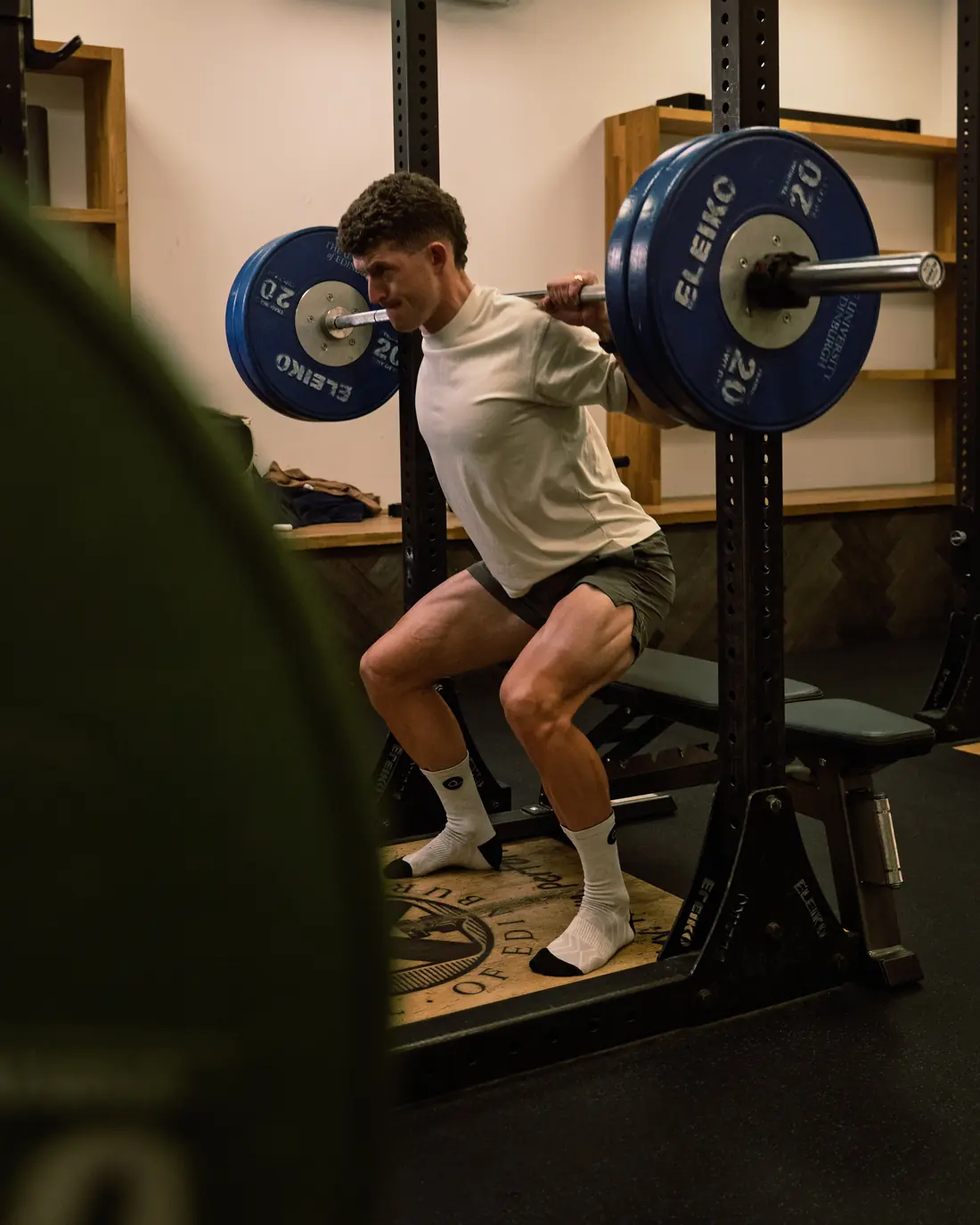 Ben Millar mid-squat with a loaded barbell in the gym