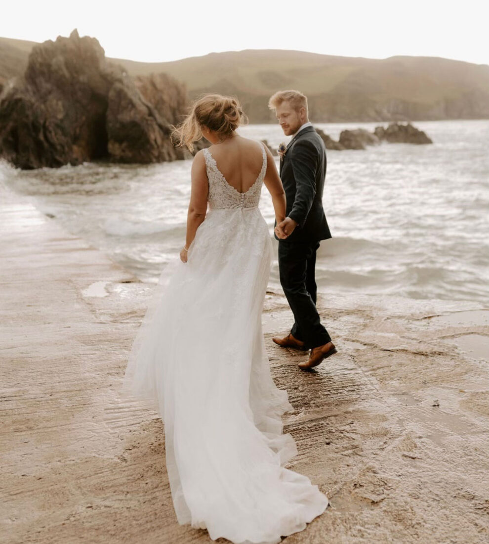 Bride and groom on a windswept beach